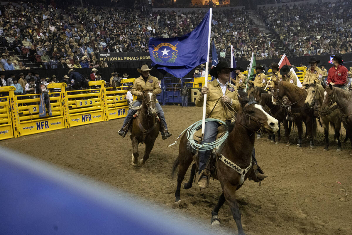 A cowboy represents Nevada with the state’s flag during the National Finals Rodeo at the Thom ...