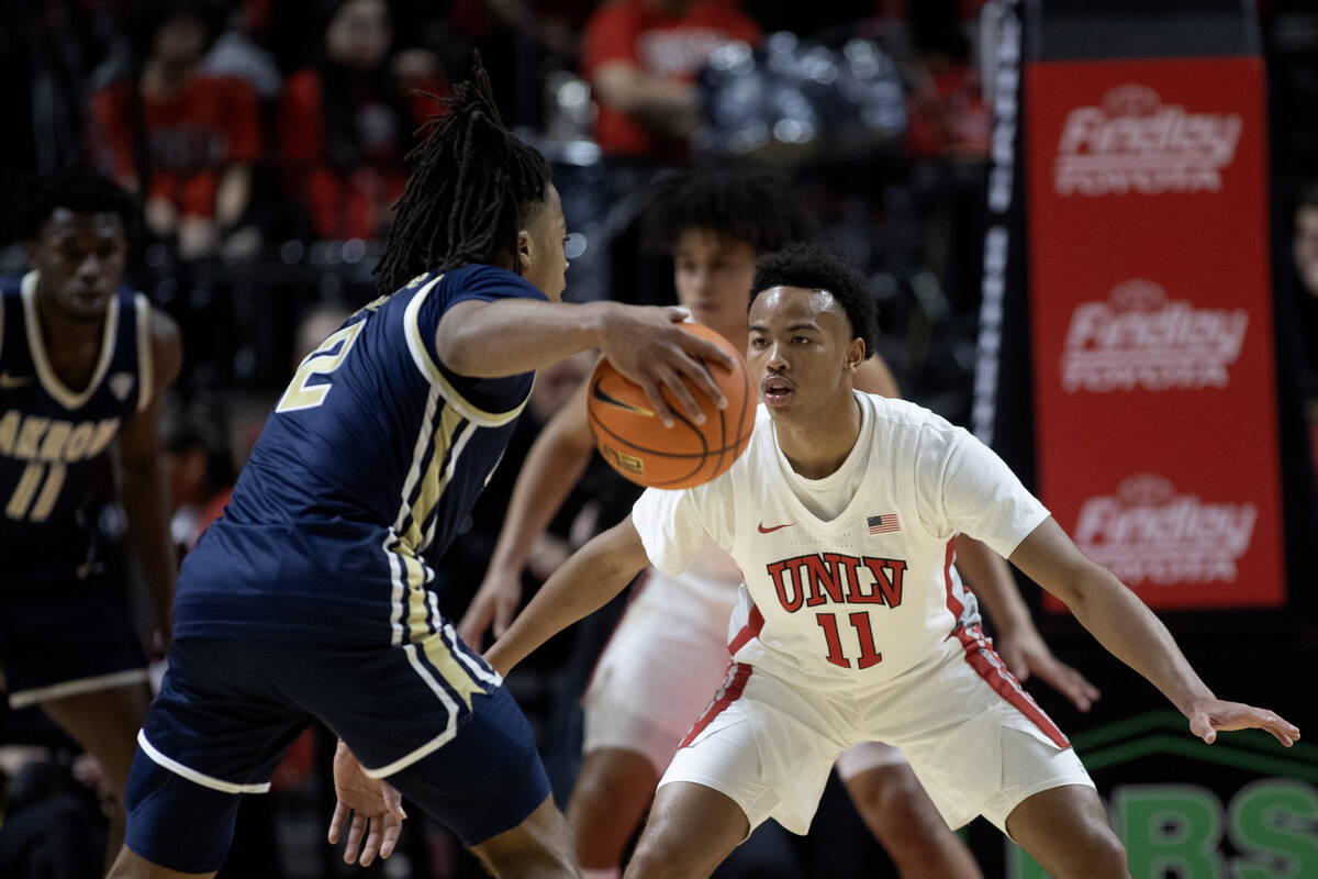 UNLV Rebels guard Dedan Thomas Jr. (11) defends against Akron Zips guard Greg Tribble (2) durin ...