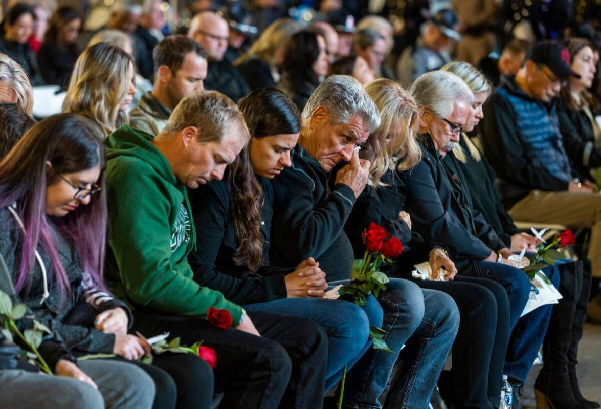 Family members and supporters take in the opening prayer during a candlelight vigil for Nevada ...