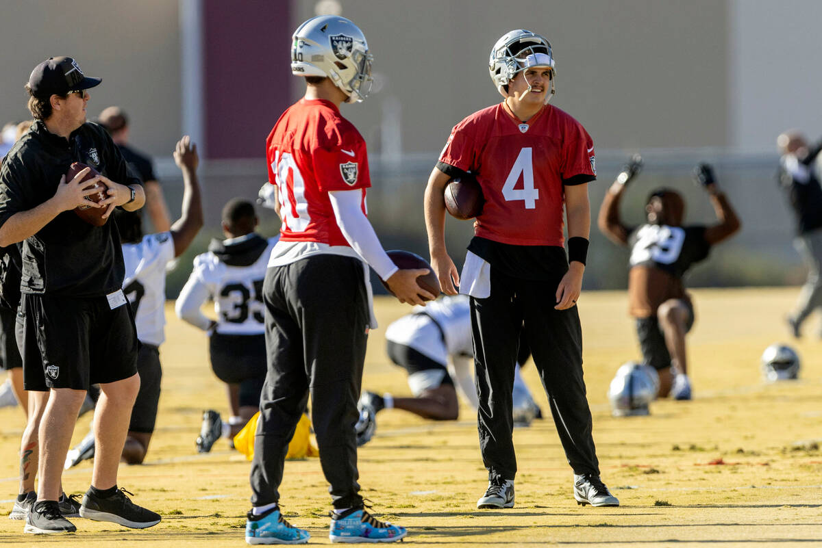 Raiders quarterback Jimmy Garoppolo (10) speaks to quarterback Aidan O'Connell (4) during pract ...