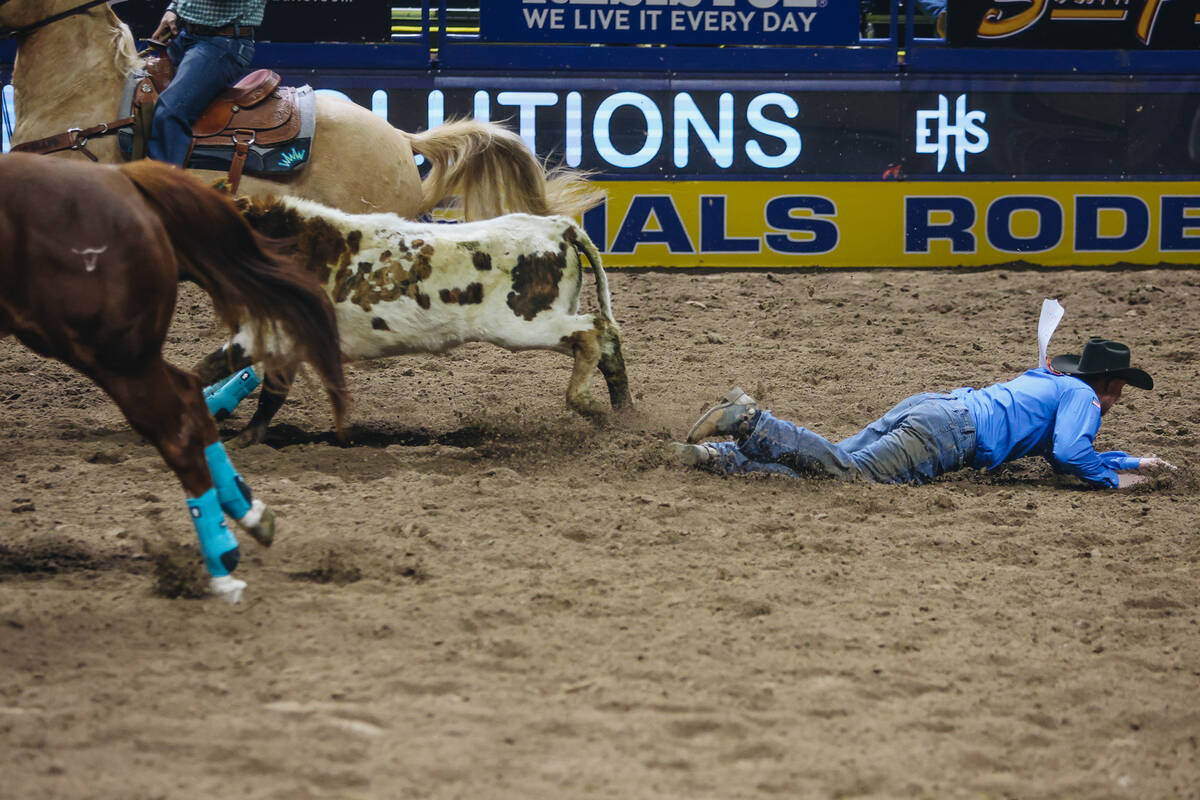 Cody Devers hits the dirt as his steer runs off during steer wrestling at the National Finals R ...