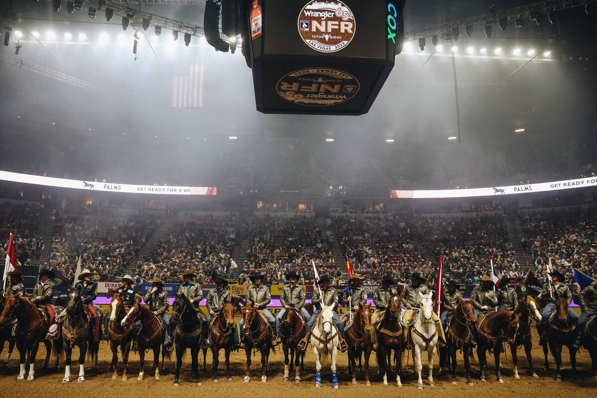 Cowboys line up during the the National Finals Rodeo opening ceremony at the Thomas & Mack Cent ...