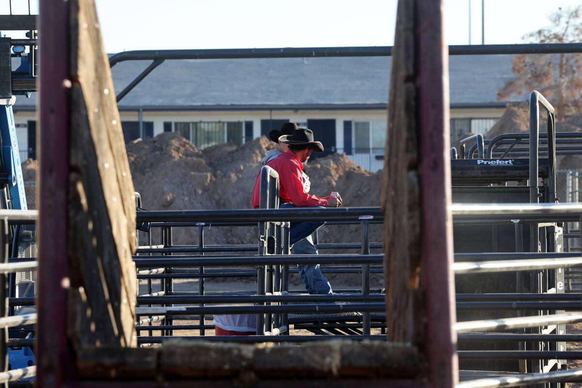 Cowboys visit in the temporary home for National Finals Rodeo livestock at the intramural field ...