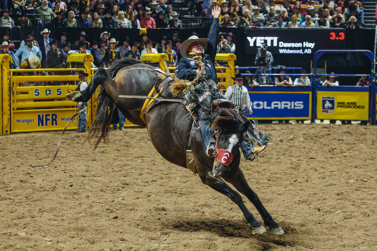 Dawson Hay gets bucked during saddle bronc riding on day three of the National Finals Rodeo at ...