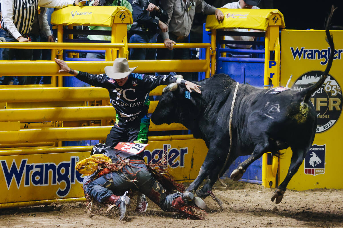 A bull charges at Trey Holston during day three of the National Finals Rodeo at the Thomas & Ma ...