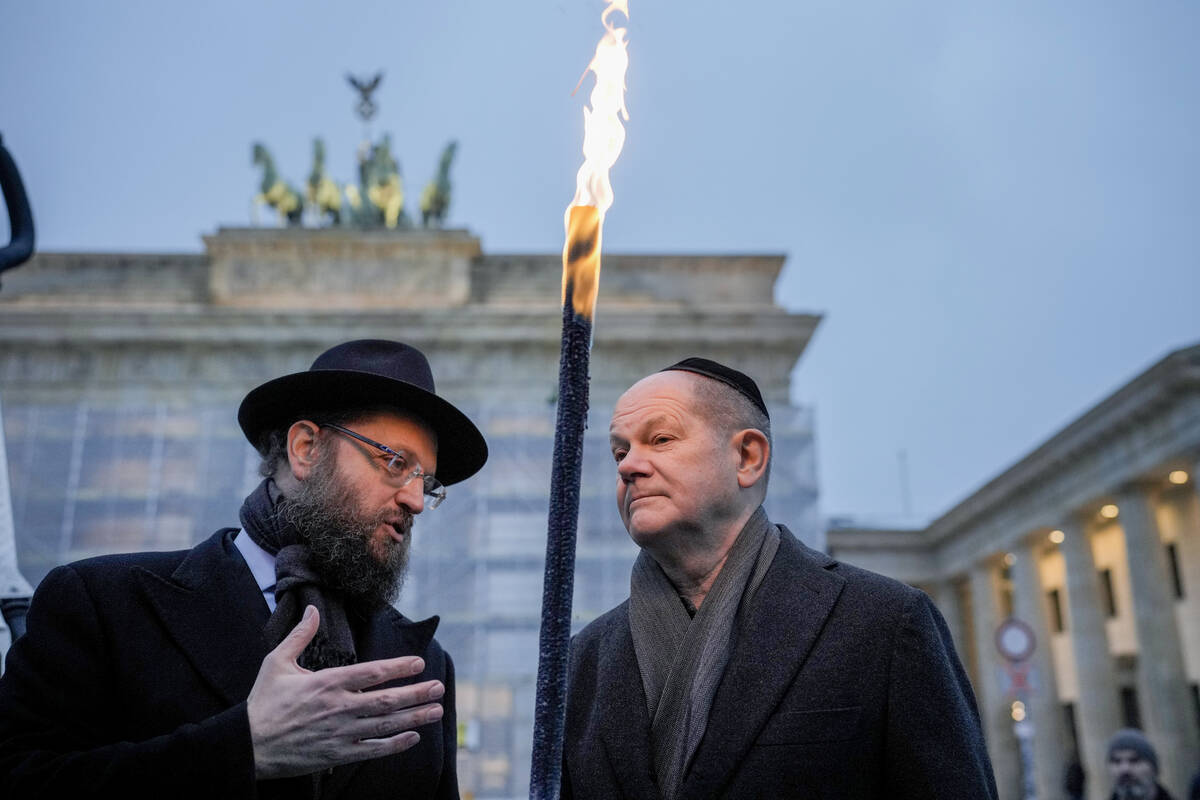 German Chancellor Olaf Scholz, right, and Rabbi Yehuda Teichtal attend the ceremony to light th ...