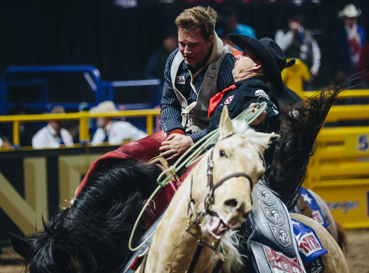 A pickup man helps Dean Thompson off of his ride after his round one bareback ride during NFR a ...