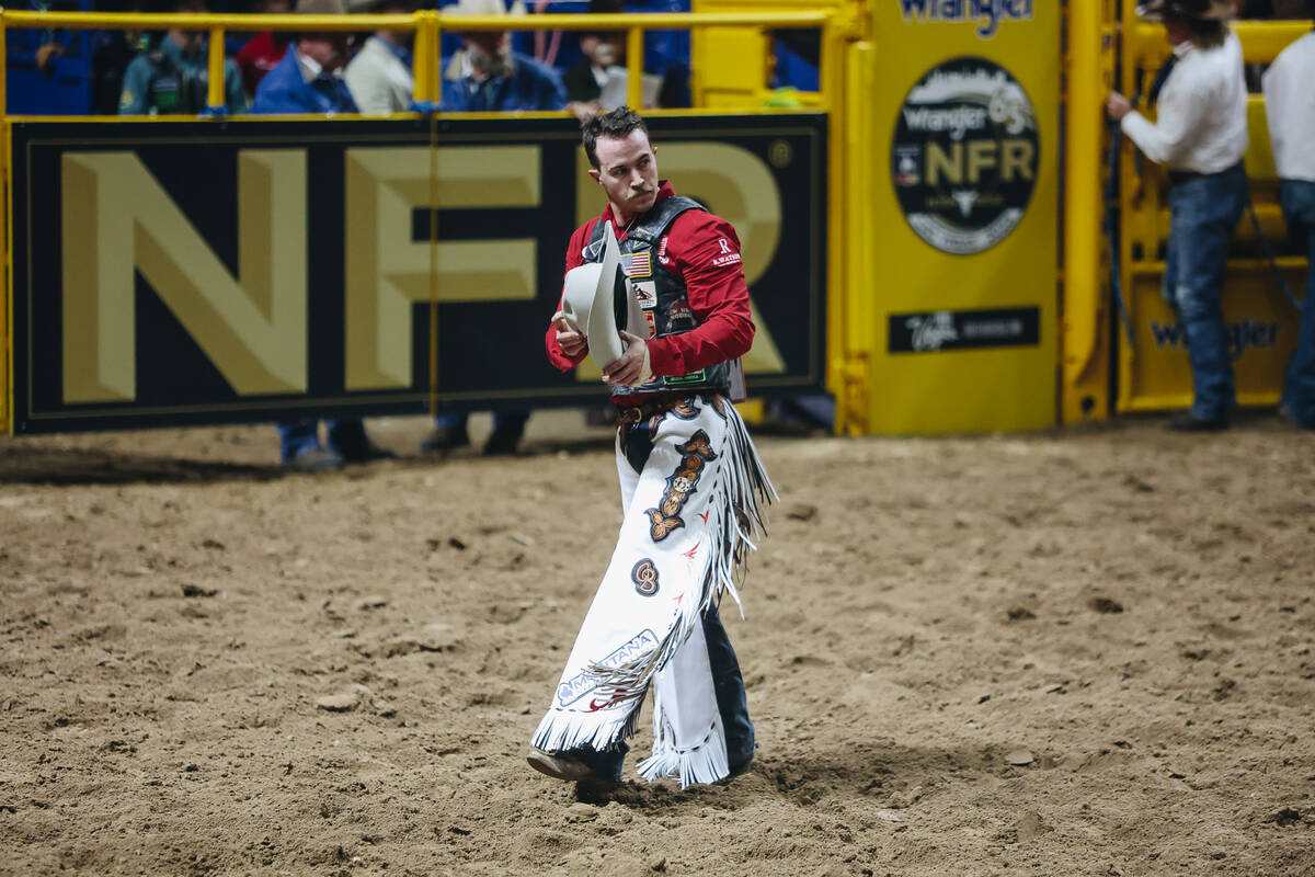 Chase Brooks walks off the dirt after his ride during the National Finals Rodeo at the Thomas & ...