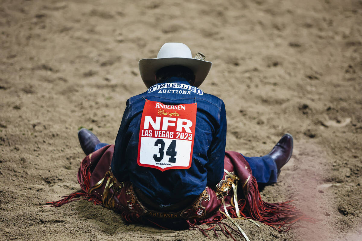 Ben Andersen sits in the dirt after his saddle bronc ride during the National Finals Rodeo at t ...