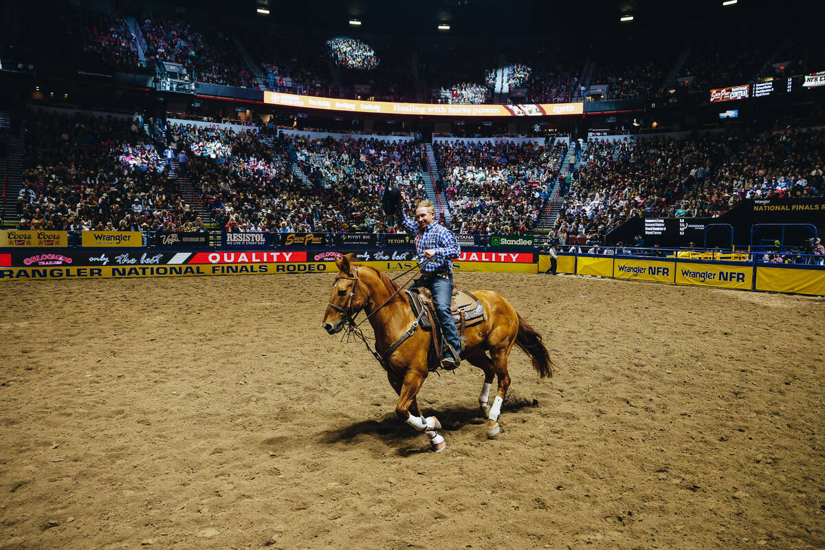 Clint Summers tips his hat to the crowd during his victory lap at the National Finals Rodeo at ...