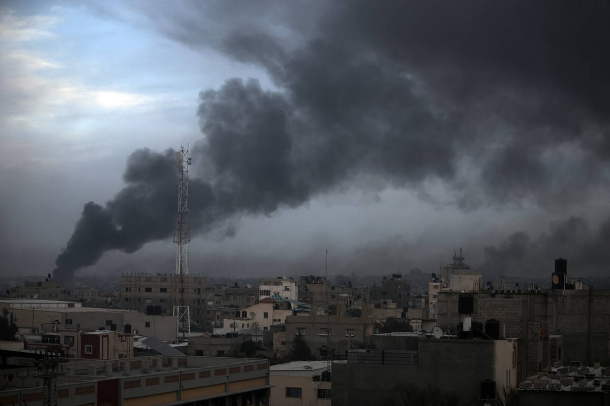 Smoke rises from town of Khan Younis after Israeli strikes on Sunday, Dec. 10, 2023. (AP Photo/ ...