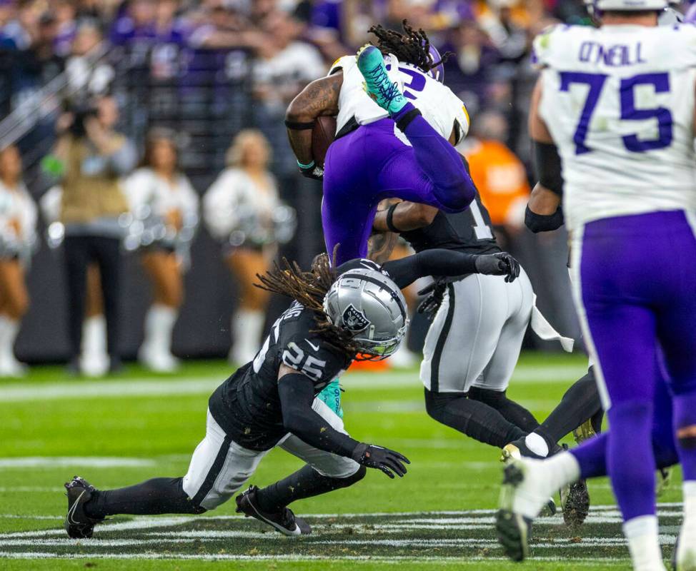 Minnesota Vikings running back Alexander Mattison (2) is upended on a run by Raiders safety Tre ...