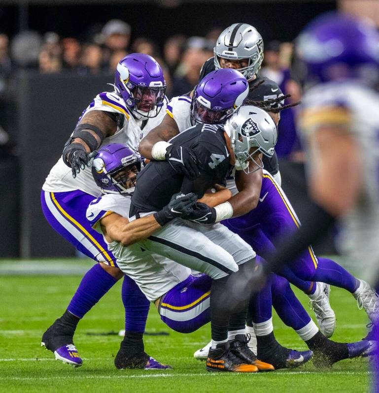 Raiders quarterback Aidan O'Connell (4) is sacked by Minnesota Vikings defenders during the fir ...