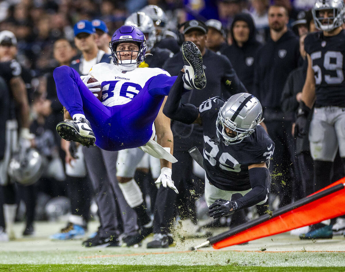 Minnesota Vikings tight end Johnny Mundt (86) is upended on a tackle by Raiders cornerback Nate ...
