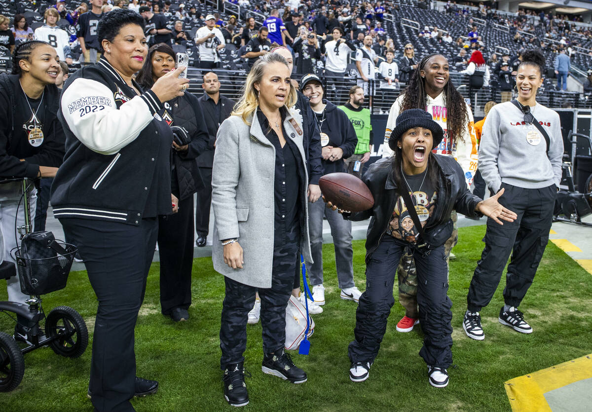 Members of the Las Vegas Aces joke around on the sidelines before the start of the NFL game wit ...