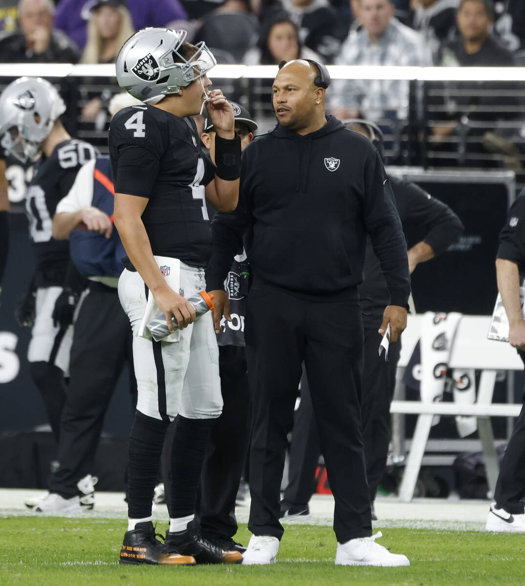Raiders quarterback Aidan O'Connell (4) listens to Interim Head Coach Antonio Pierce during the ...