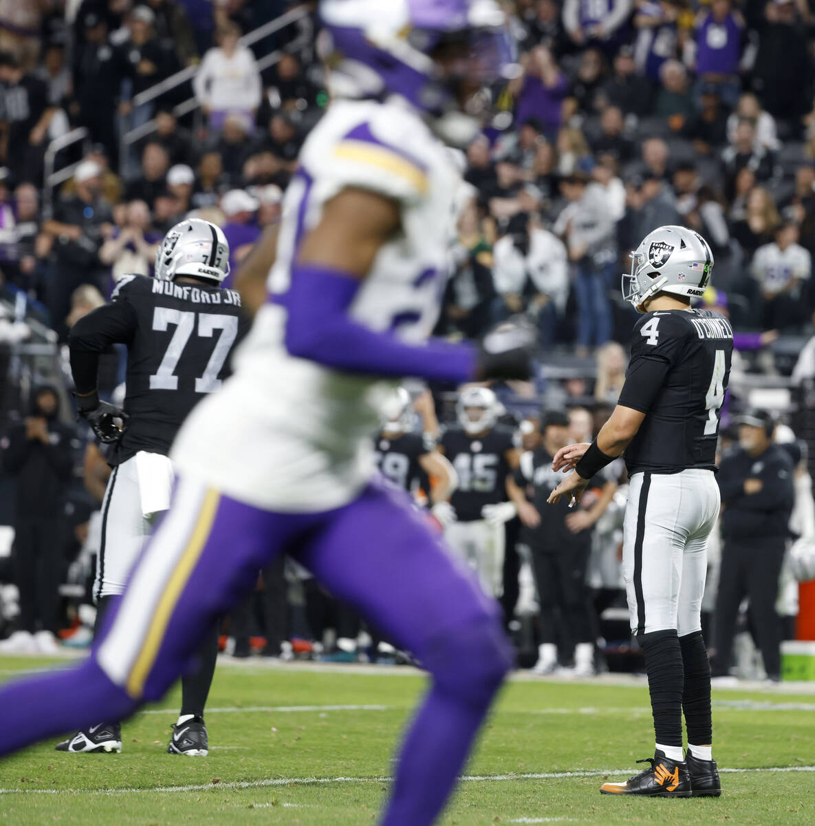 Raiders quarterback Aidan O'Connell (4) and Raiders offensive tackle Thayer Munford Jr. (77) wa ...