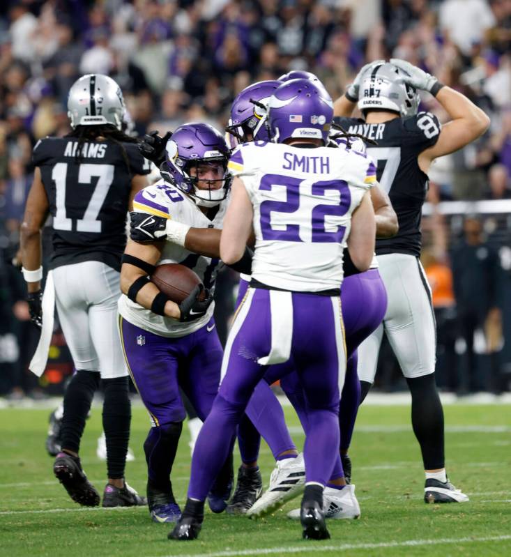 Raiders wide receiver Davante Adams (17) and Raiders tight end Michael Mayer (87) walk off the ...