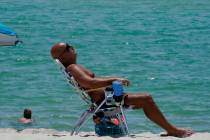 A sunbather enjoys the sun, Wednesday, July 12, 2023, in Miami Beach, Fla. Miami Dade County ha ...