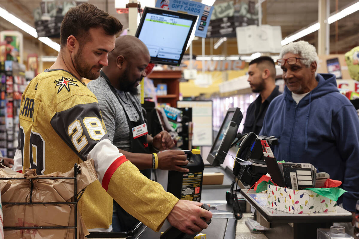 Golden Knights left wing William Carrier helps customers check out at a Smith's on Monday durin ...
