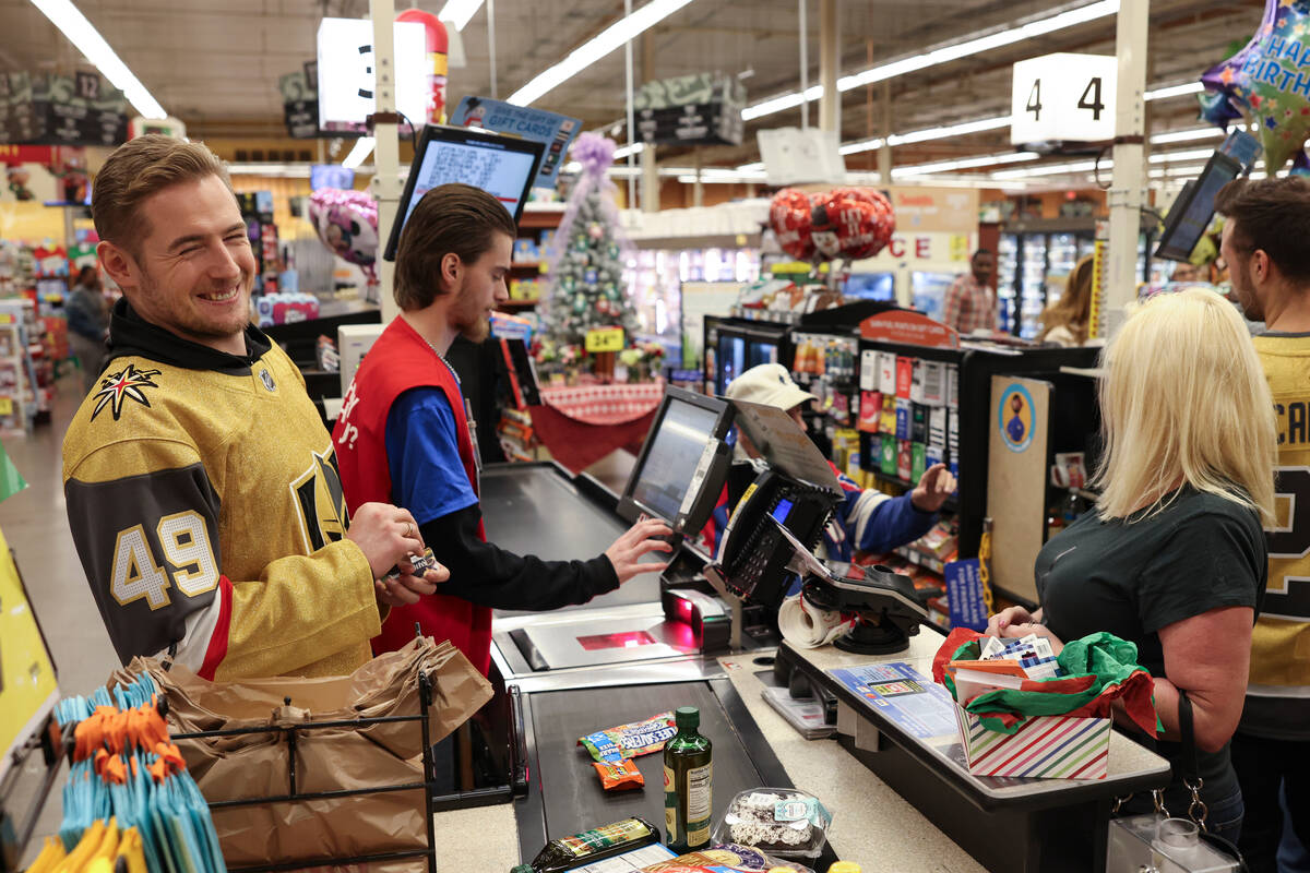 Golden Knights left wing Ivan Barbashev helps customers check out at a Smith's on Monday during ...