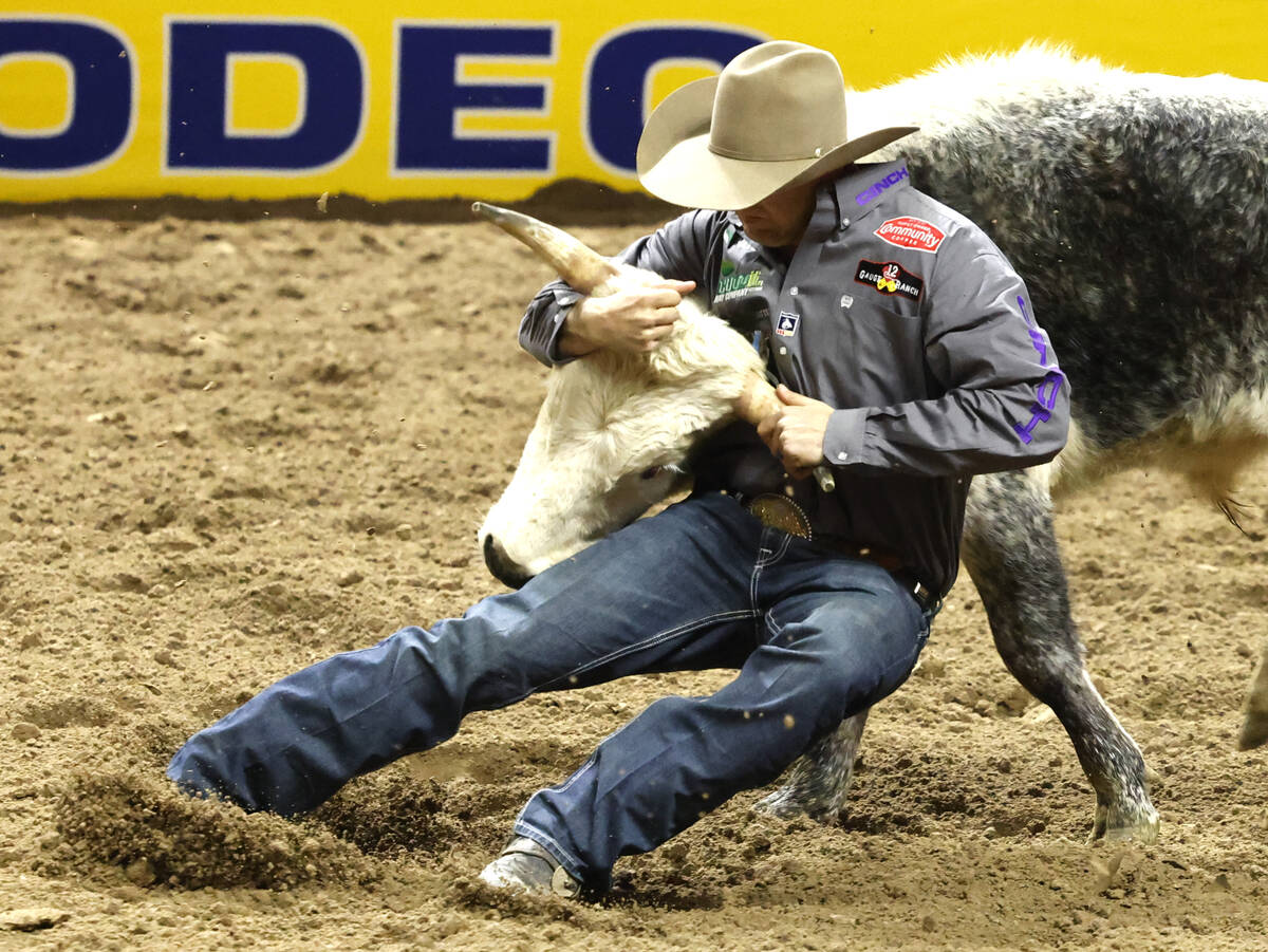 Tyler Waguespack wrestles a steer to the ground while he competes in steer wrestling on day six ...