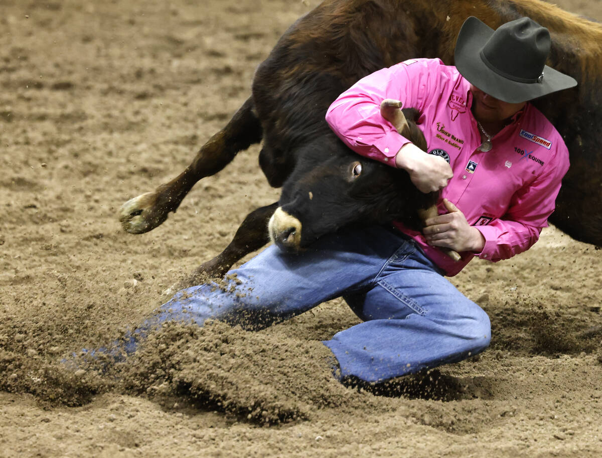 Cody Devers wrestles a steer to the ground while he competes in steer wrestling on day six of t ...