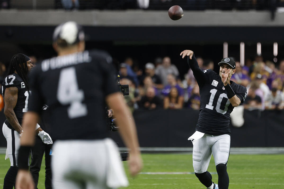 Raiders quarterback Jimmy Garoppolo (10) throws the ball to Aidan O'Connell (4) as they warm up ...