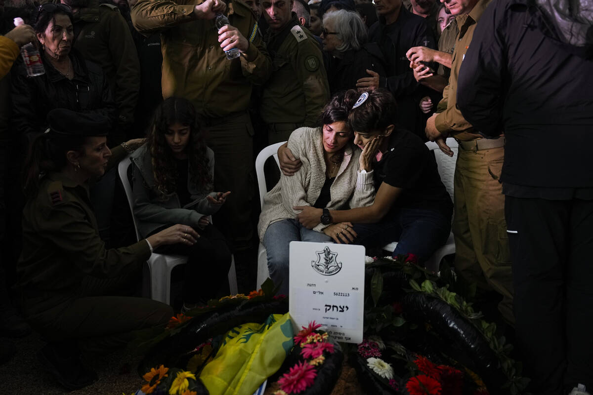 Family and friends of Israeli soldier Col. Itzhak Ben Basat mourn over his grave during his fun ...
