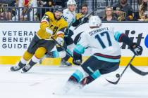 Golden Knights defenseman Shea Theodore (27) passes the puck past Seattle Kraken center Jaden S ...