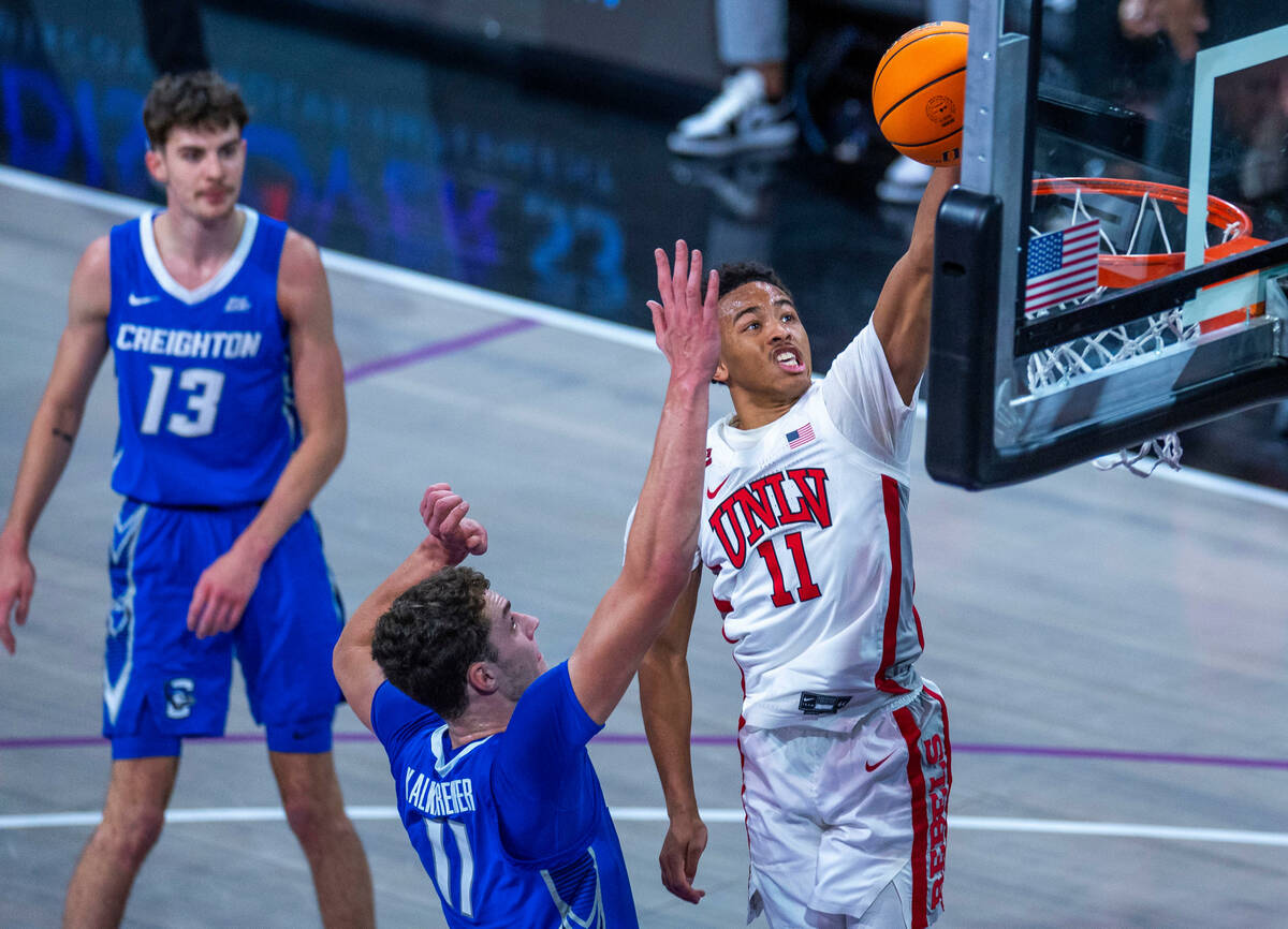 UNLV Rebels guard Dedan Thomas Jr. (11) soars to the rim above Creighton Bluejays center Ryan K ...