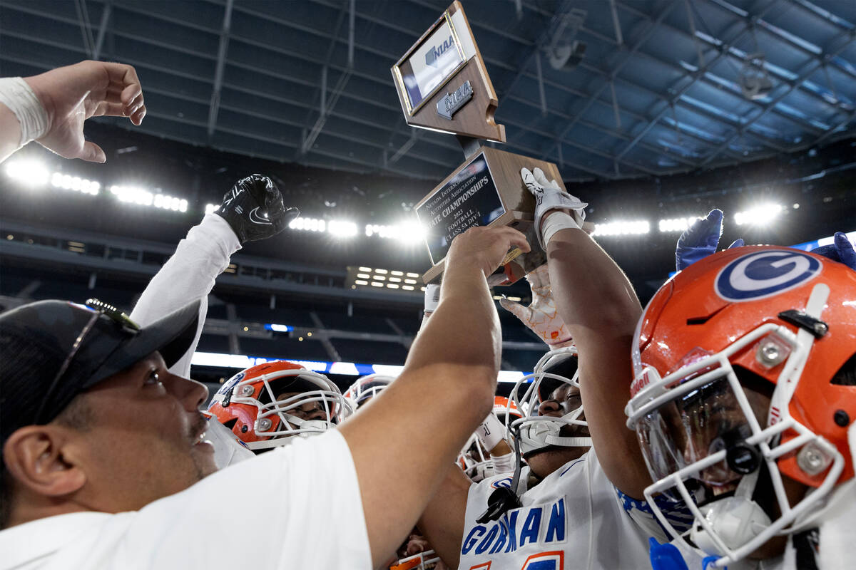 Bishop Gorman holds up their Class 5A Division I high school football state championship trophy ...