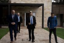 Israel's President Isaac Herzog, center, walks with his staff after an interview at his officia ...