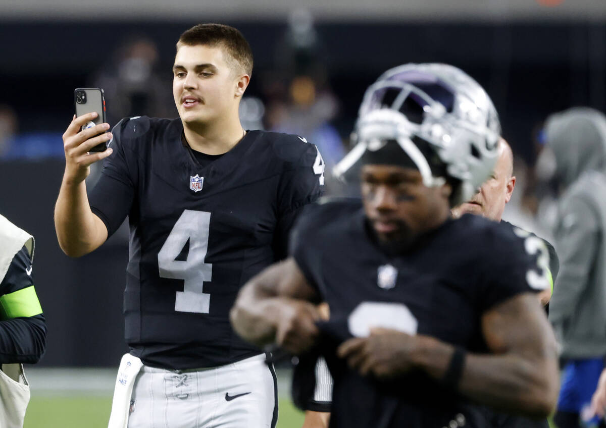 Raiders quarterback Aidan O'Connell (4) talks on the phone as he leaves the field after his tea ...