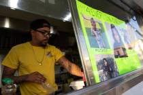 Isaiah Robinson, owner of Trap Wingz, serves food during a fundraiser hosted by family of the m ...