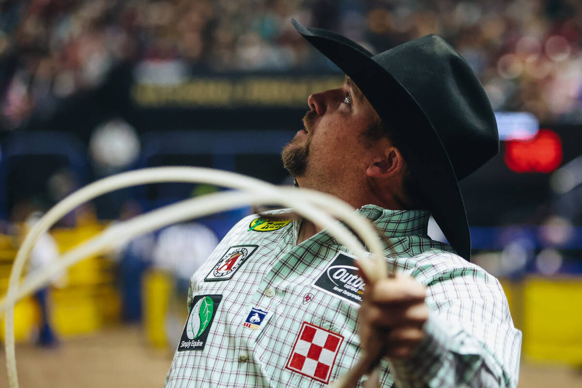 Jake Long looks to watch a replay of his team roping attempt during the National Finals Rodeo a ...