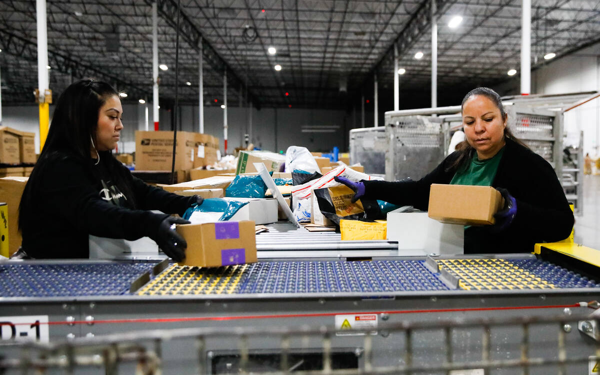 Kim Lopez, left, and Aureoia Garcia, USPS employees, sort packages at a distribution center les ...