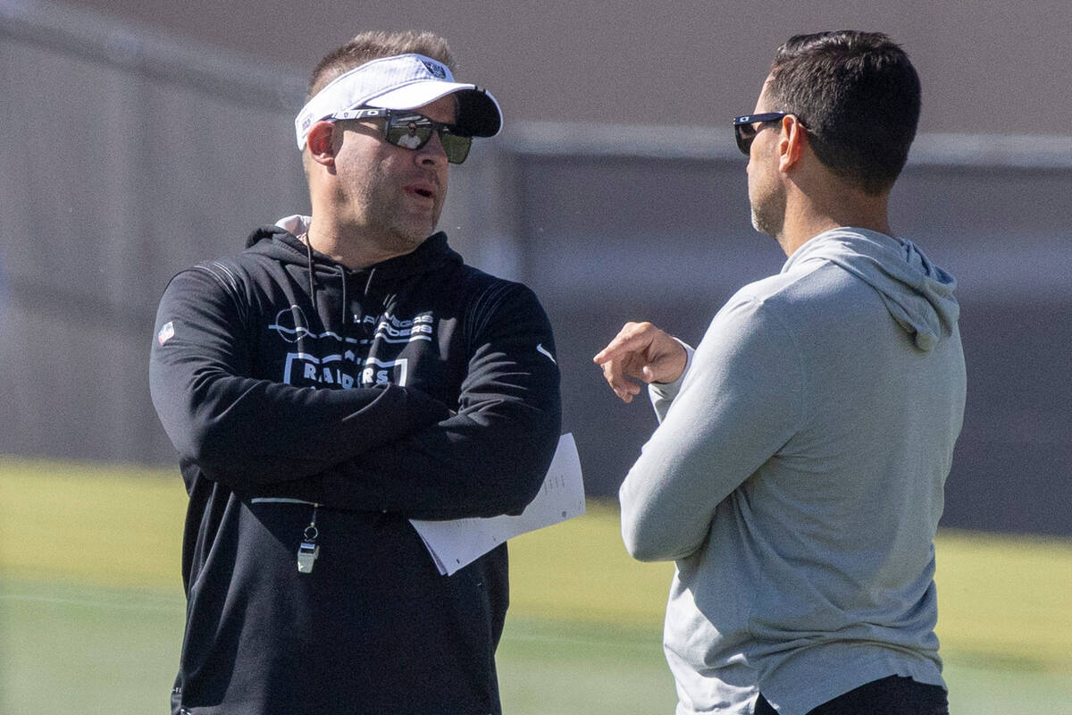 Raiders head coach Josh McDaniels, left, and general manager Dave Ziegler meet during practice ...