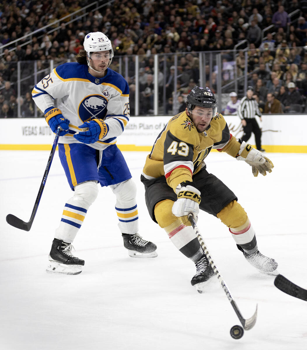 Golden Knights center Paul Cotter (43) reaches for the puck while Sabres defenseman Owen Power ...