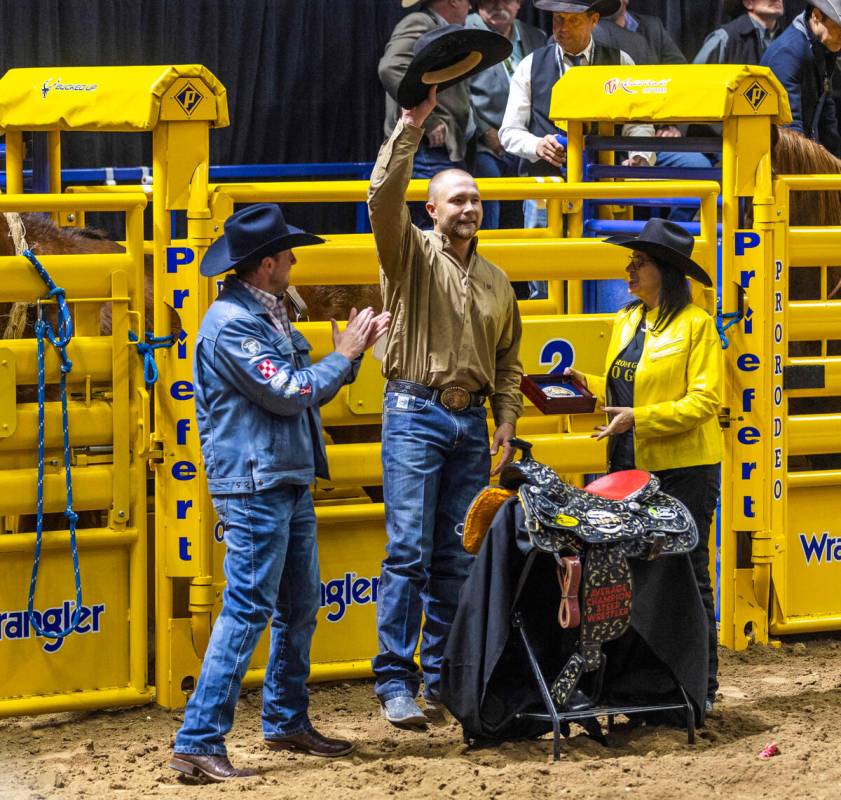 Don Payne collects a trophy and saddle after winning the overall aggregate in Steer Wrestling d ...