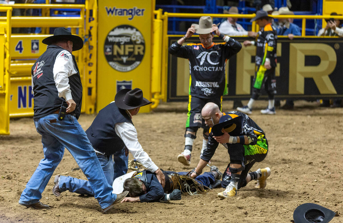 Ky Hamilton is down in the dirt as medical personnel arrive with bullfighters in Bull riding at ...