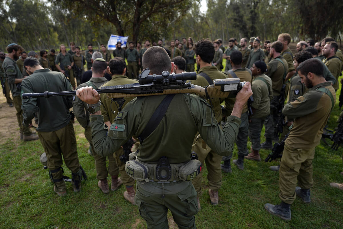 Israeli soldiers are briefed after coming back from the Gaza Strip at a staging area in souther ...