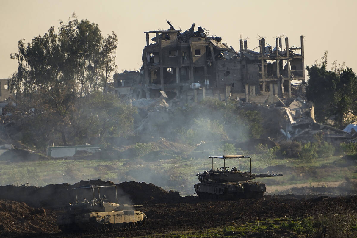 Israeli tanks are seen next to a destroyed building during a ground operation in the northern G ...