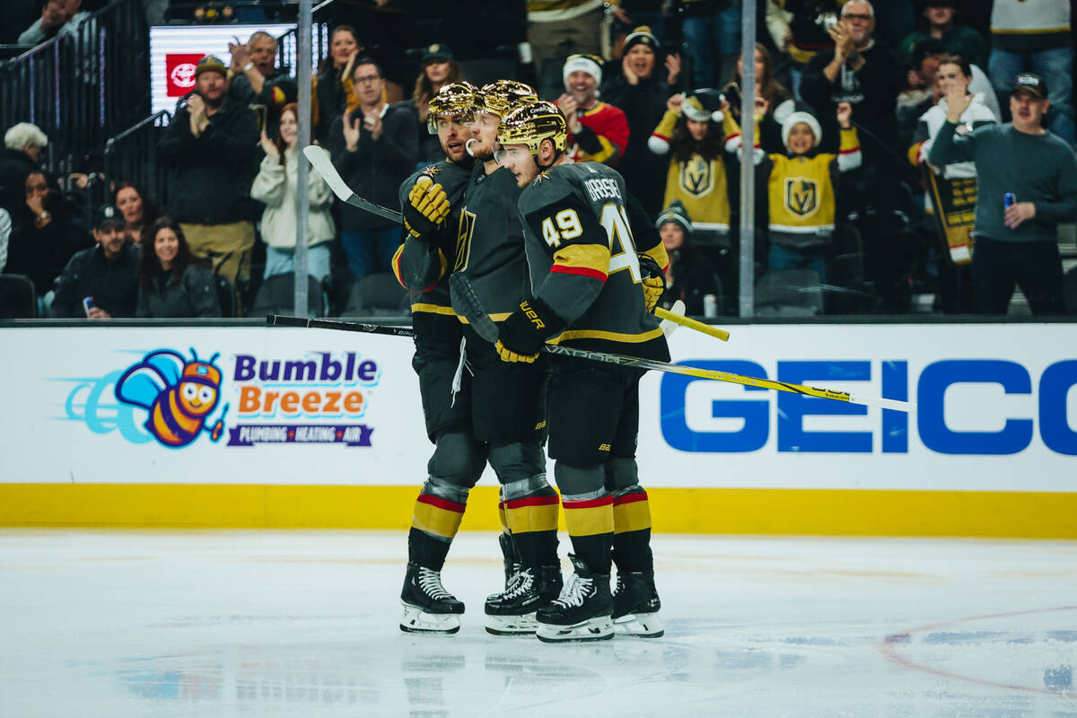 The Golden Knights hug as they celebrate their first goal of the night during a game against th ...