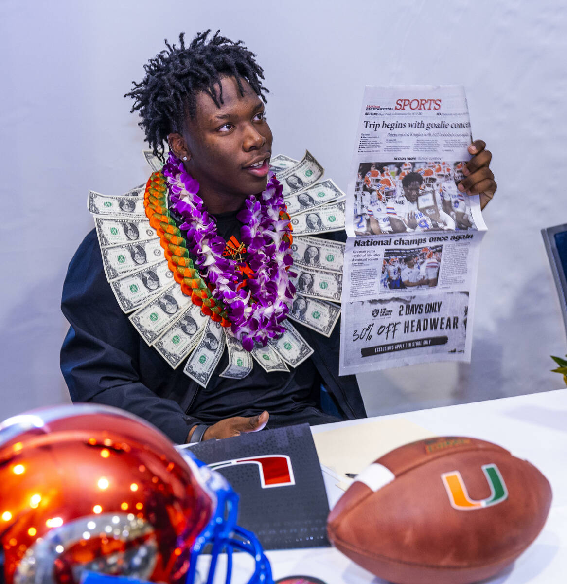 Bishop Gorman player Elija Lofton with a commitment letter to the University of Miami holds up ...