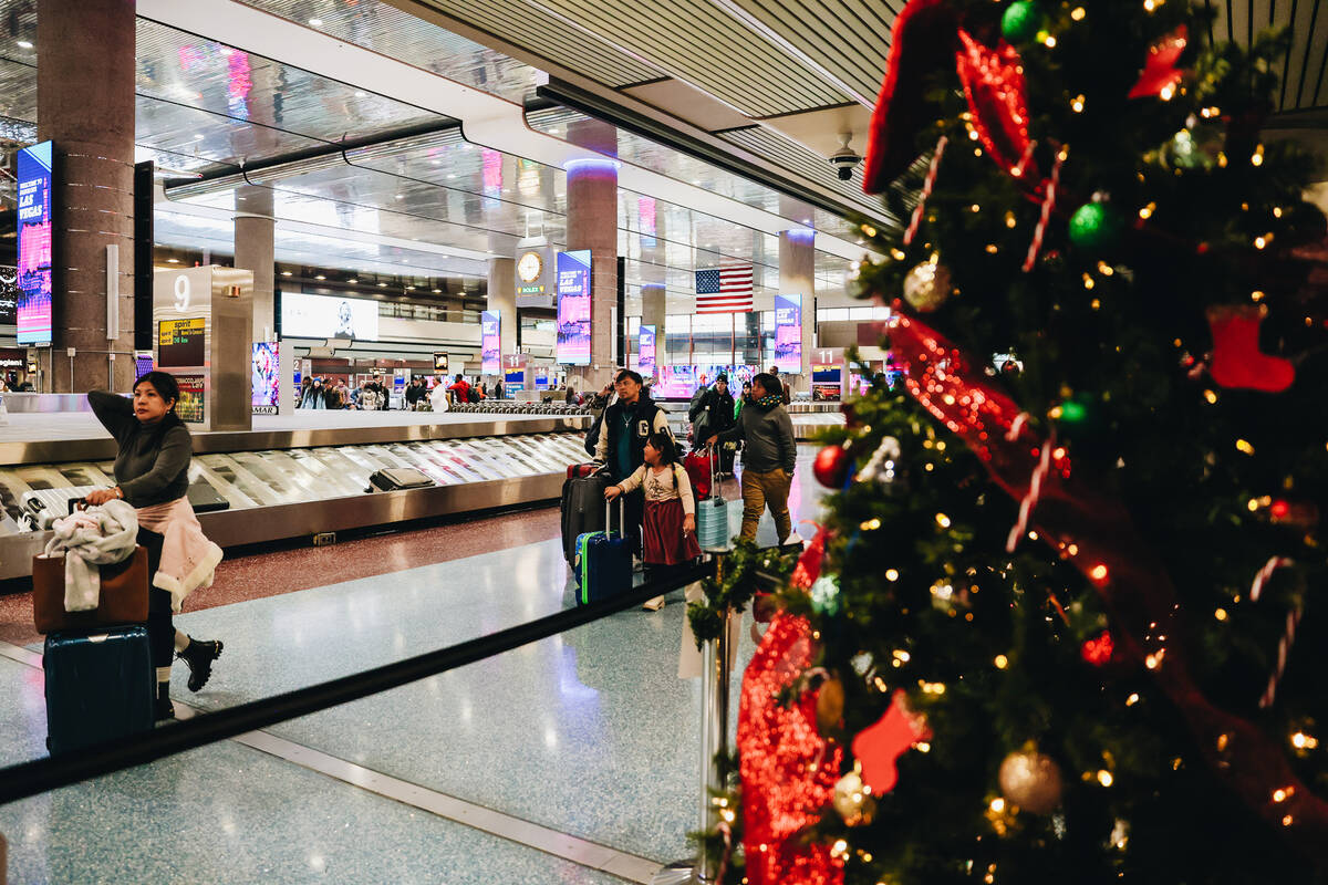 Travelers walk through the baggage claim area at Harry Reid International Airport on Wednesday, ...