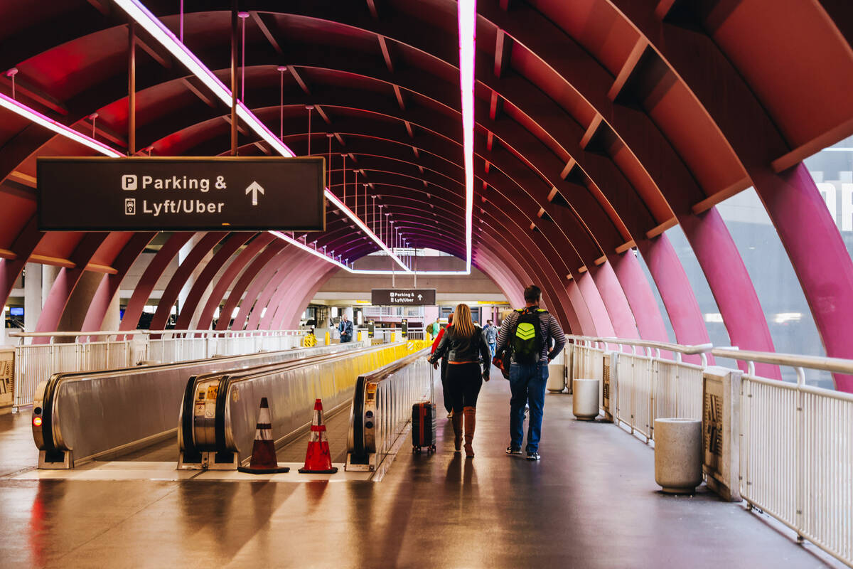 Travelers walk to the parking and pick up area at Harry Reid International Airport on Wednesday ...