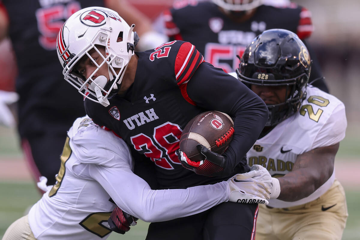 Utah running back Sione Vaki (28) is tackled by Colorado linebacker Demouy Kennedy (22) and lin ...