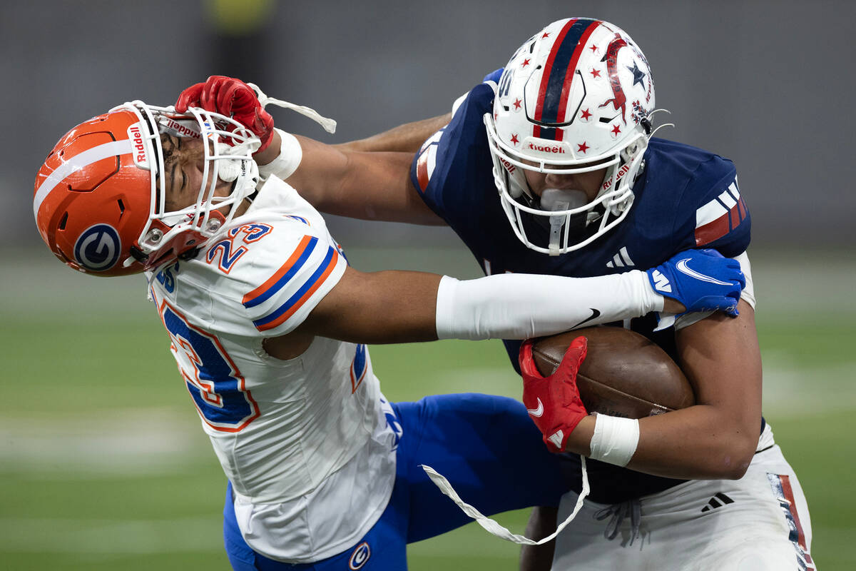 LIberty’s Andre Porter (2) pushes Bishop Gorman’s Aidan Zehner (23) while carryin ...
