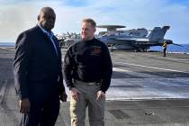 Defense Secretary Lloyd Austin, left, talks with the commanding officer of the USS Gerald R. Fo ...